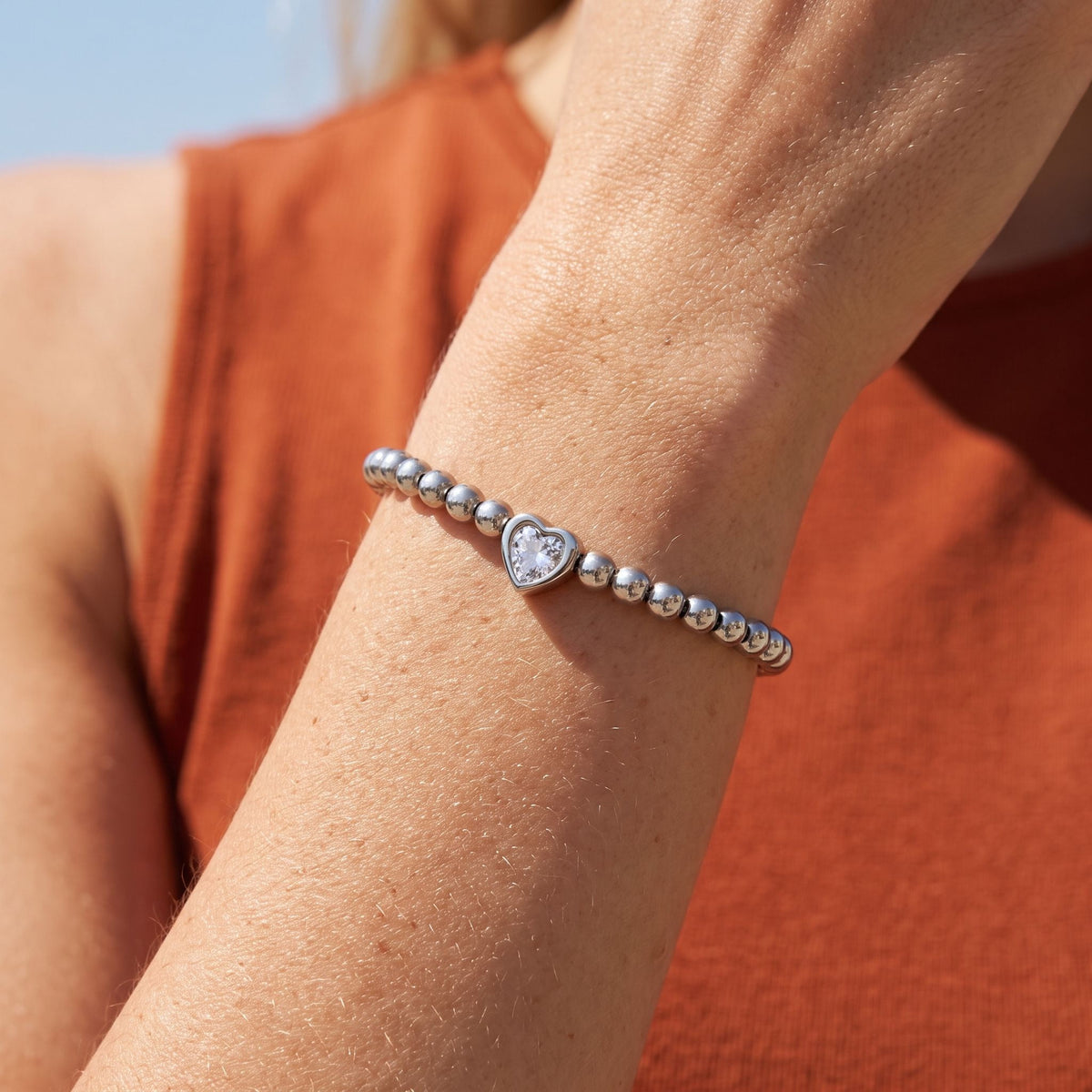 Silver Heart Bracelet worn on the wrist, photographed in natural daylight.