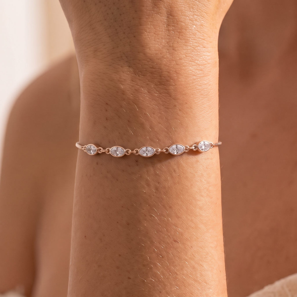 Close-up of the rose gold Oval Bezel Bracelet on the wrist, highlighting the bezel-set oval crystals