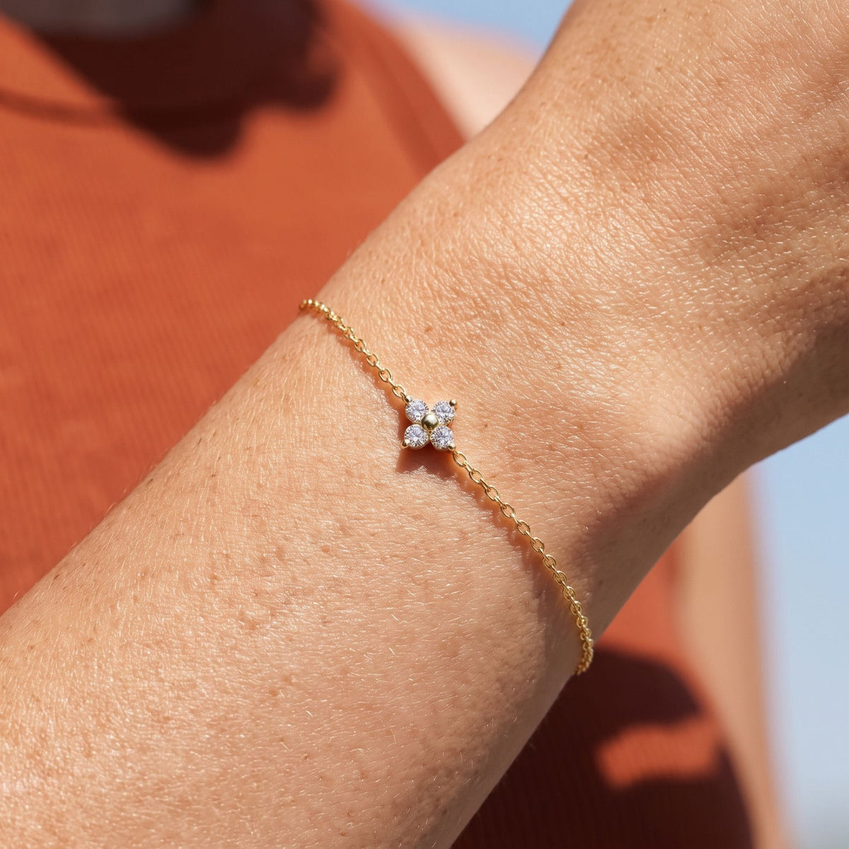 Solitaire Clover Bracelet worn on the wrist, photographed in natural daylight.