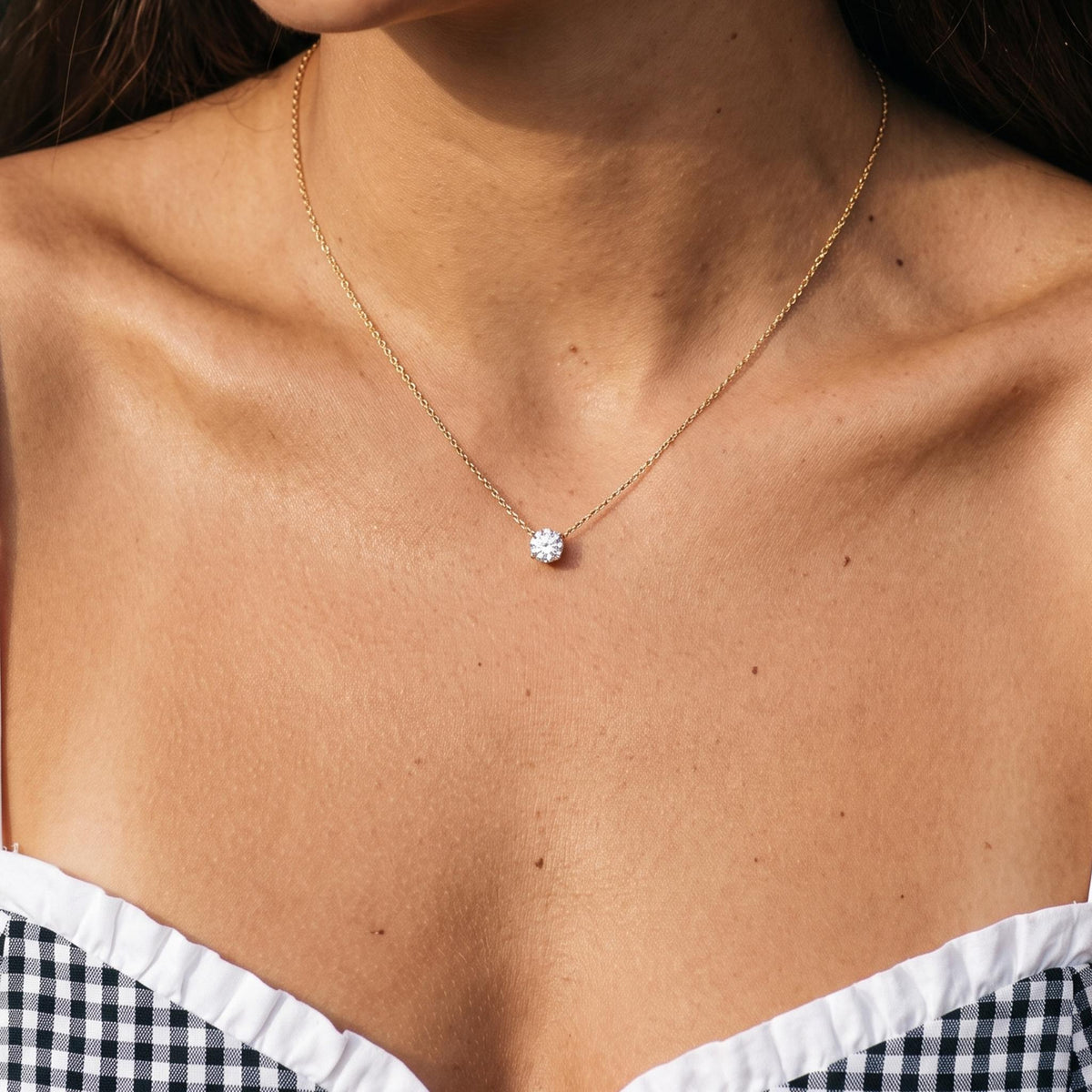 Close-up of the Solitaire Pendant worn on the neckline