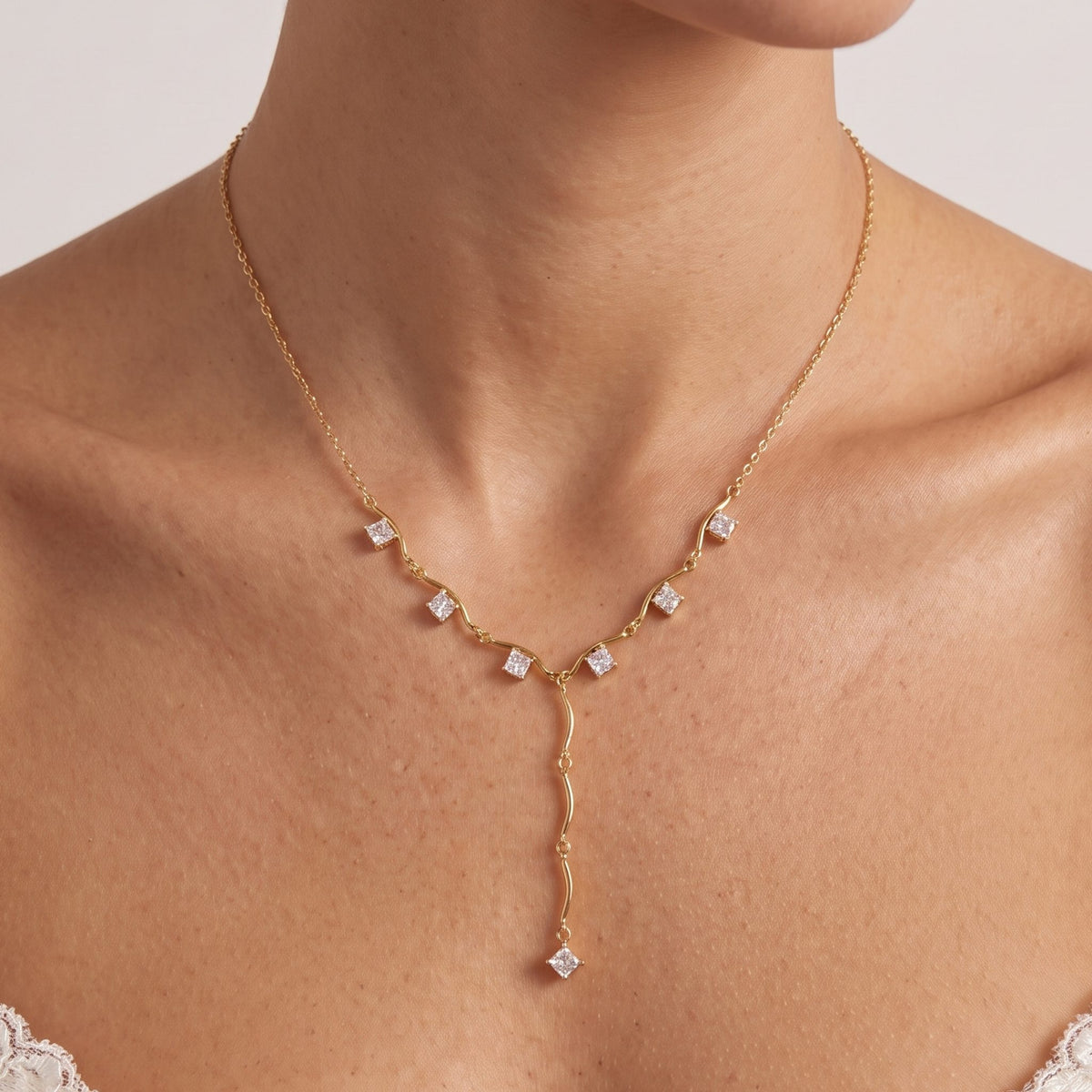 Close-up of the Square Lariat Necklace worn at the collarbone showing square crystal accents along a gold chain