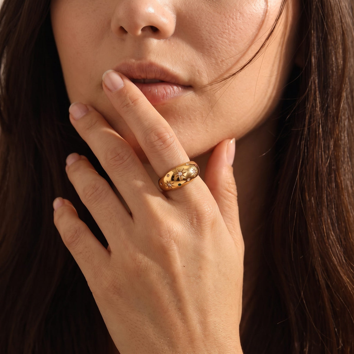 Woman wearing the Star Dome Ring on her hand, touching her lips with her index finger