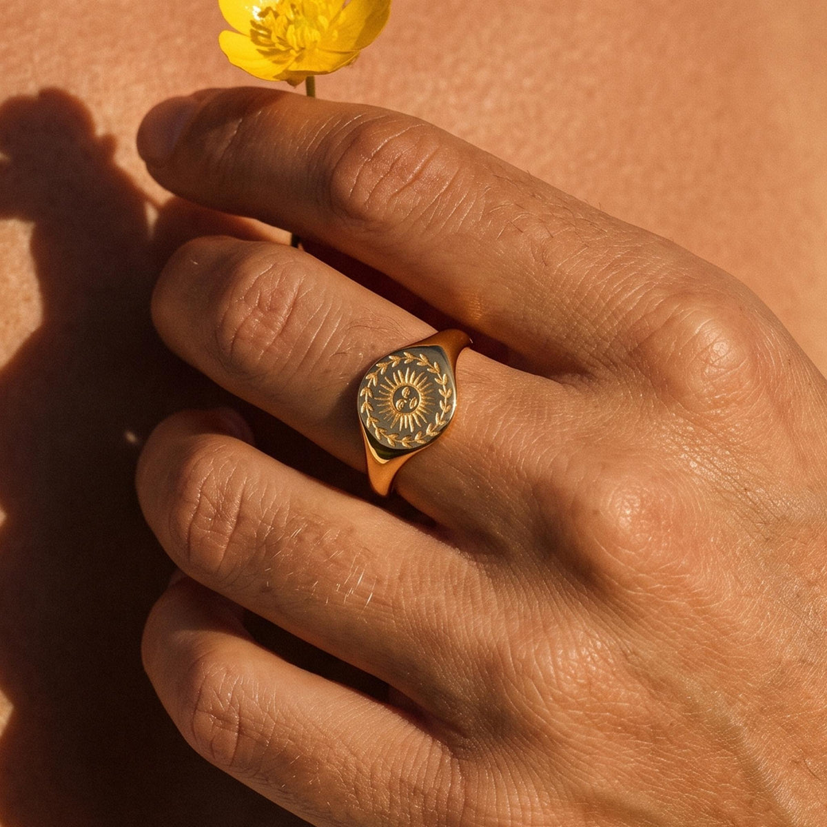 Close-up of the Sunflower Signet Ring worn on the finger
