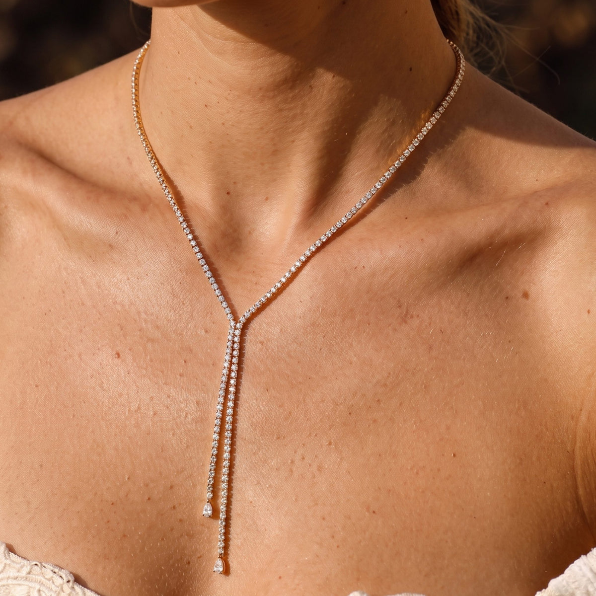 Close-up of the Tennis Lariat Necklace at the collarbone featuring dangling crystal drops