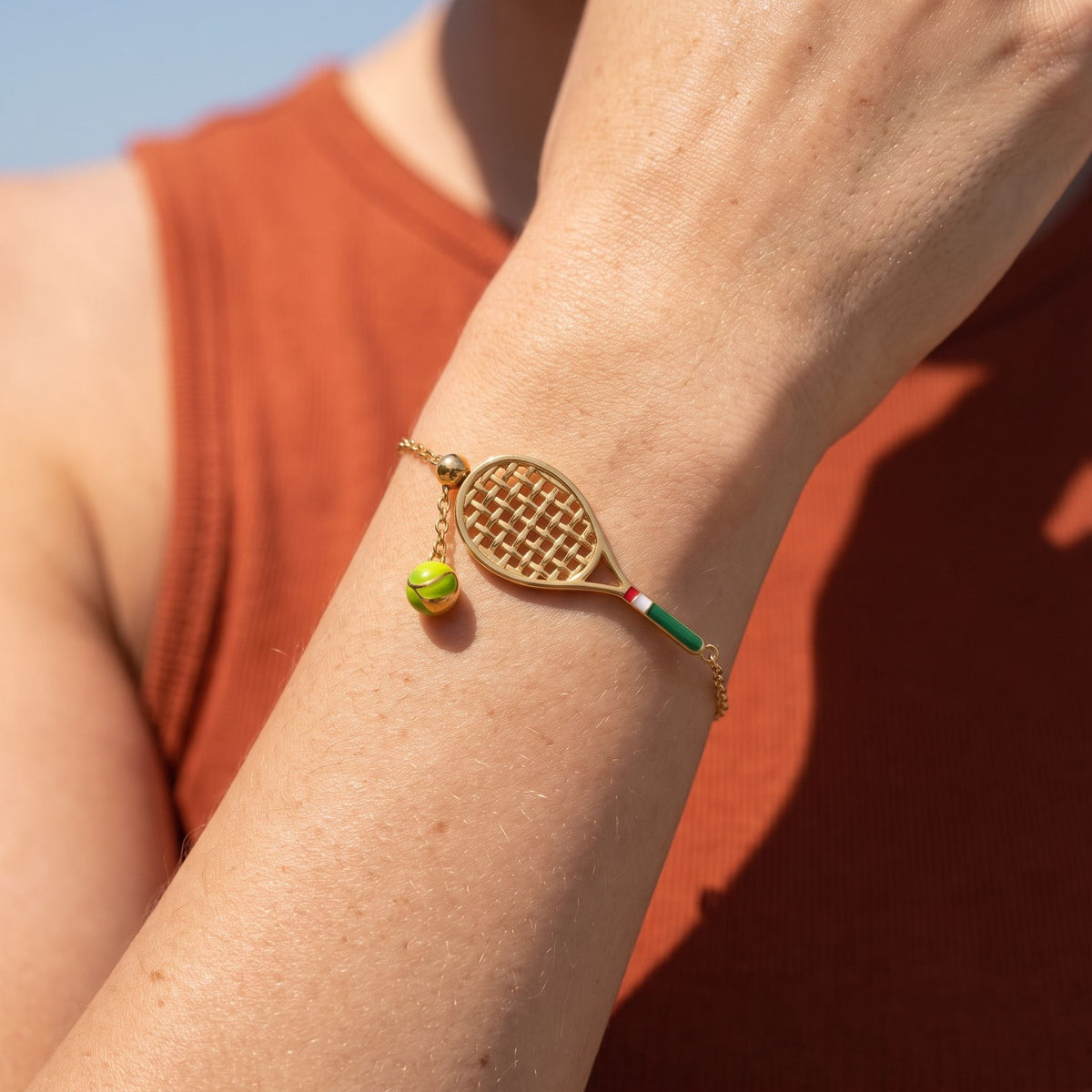 Tennis Racket Bracelet worn on the wrist, photographed in natural daylight.