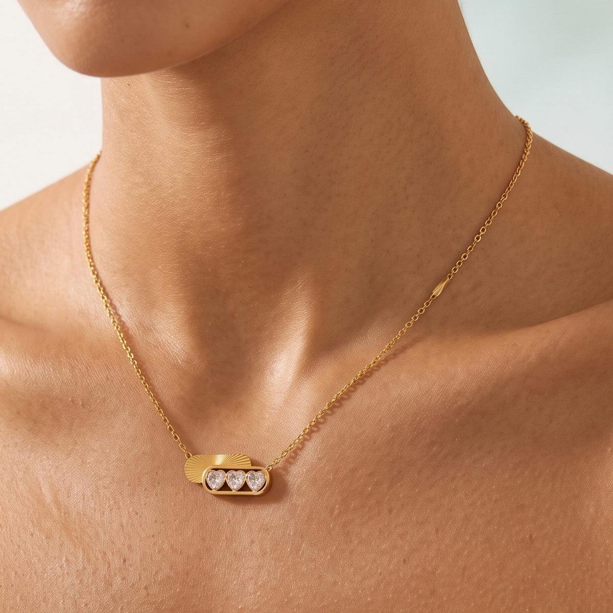 Close-up of the Triple Heart Necklace at the collarbone showing three sparkling heart crystals