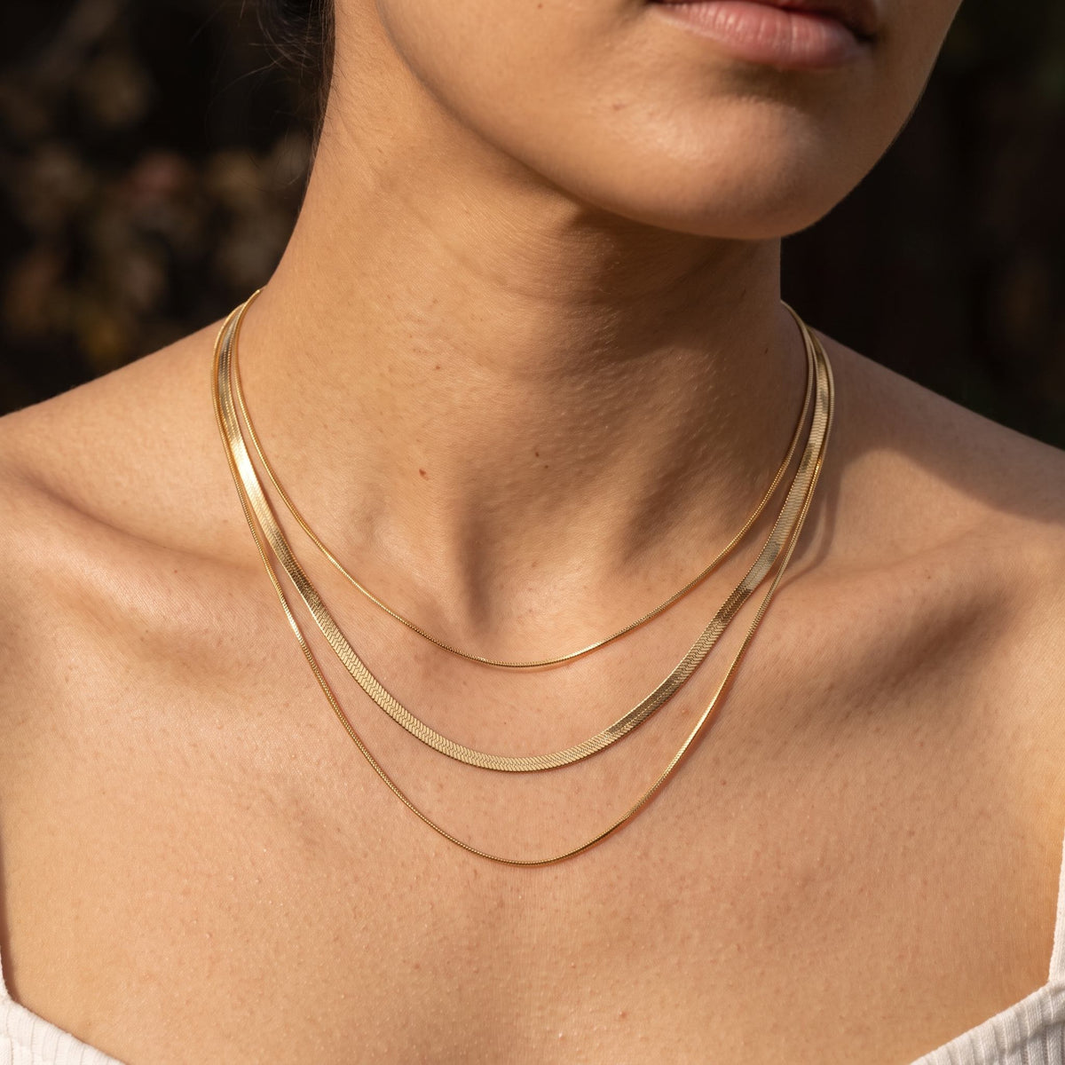 Wider view of a woman wearing the Triple Herringbone Necklace
