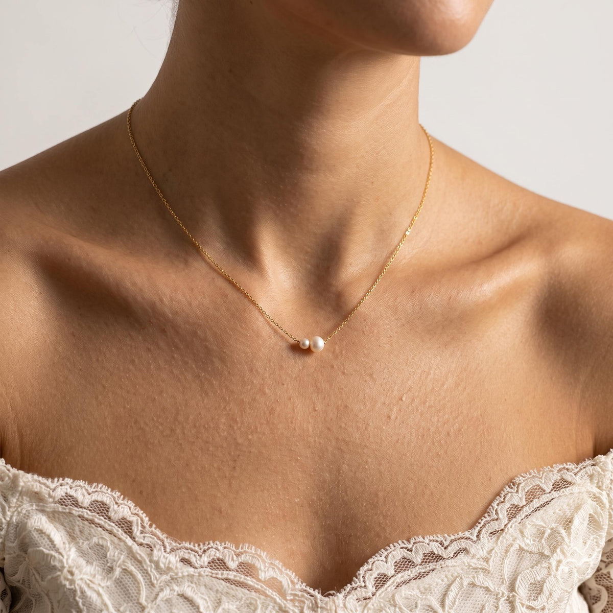Wider view of a woman wearing the Twin Pearl Pendant