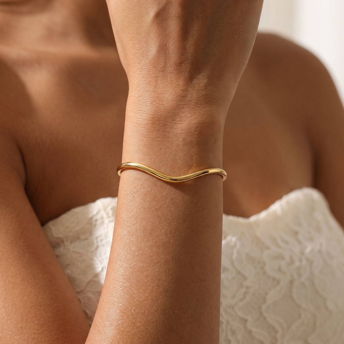 Wave Bangle worn on the wrist, photographed in natural daylight.