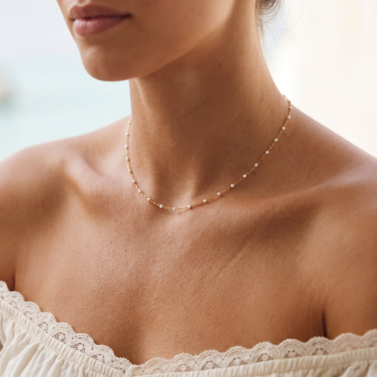Wider view of a woman wearing the White Bead Necklace